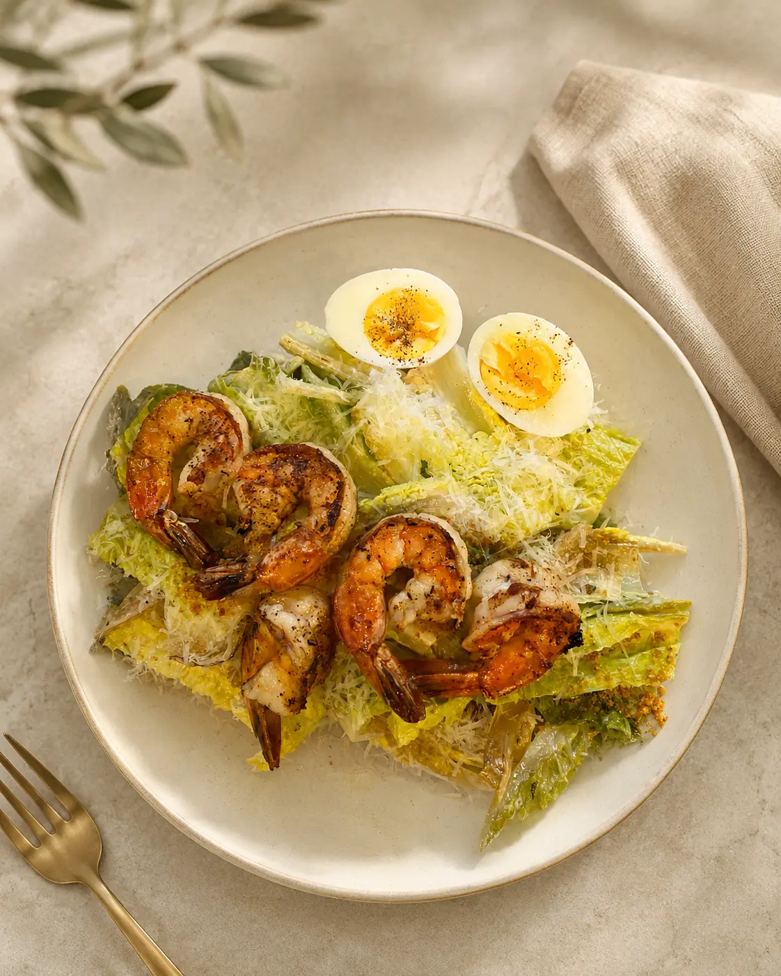 A grilled shrimp salad plated with soft-boiled egg and shaved parmesan